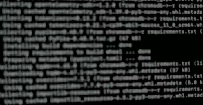 Un terminale che installa le librerie di un progetto: righe di testo che scorrono su fondo nero. Filmato di repertorio.